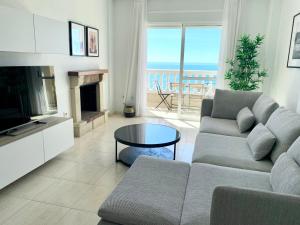 a living room with a couch and a television and a table at Panoramic Sea Views with Balcony, Air Conditioning and Parking in Aguadulce