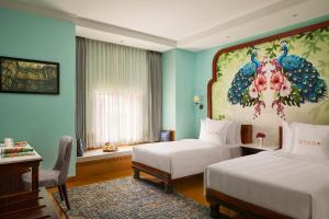 a hotel room with two beds and a painting on the wall at Storii By ITC Hotels, Jaisalmer in Jaisalmer
