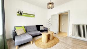 ein Wohnzimmer mit Sofa und Tisch in der Unterkunft L'Atelier d'Antoine in Longeville-lès-Metz