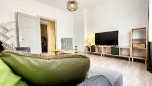 ein Wohnzimmer mit Couch und Flachbildfernseher in der Unterkunft L'Atelier d'Antoine in Longeville-lès-Metz