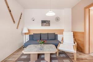 Una sala de estar con un sofá azul y una mesa. en Ferienwohnung Ufert, en Meißen