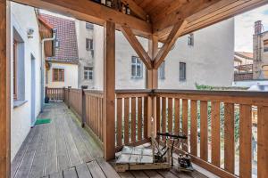 Un porche de madera con una terraza de madera en Ferienwohnung Ufert, en Meißen