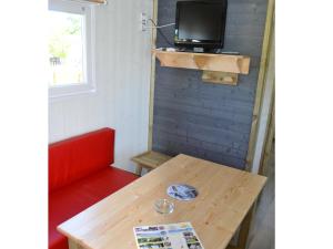 a room with a table and a tv on a wall at Camping Au Lac d'Hautibus in Argenton-Château