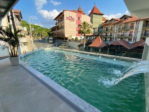 a swimming pool at a hotel with a fountain at Hotel Rouxinol in Piratuba