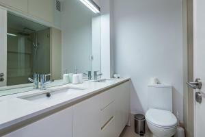 a white bathroom with a sink and a toilet at Sunset Guest House in Matosinhos +48 photos