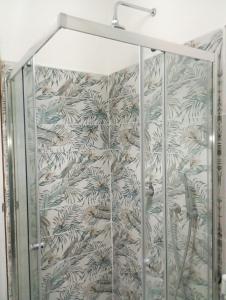 a shower stall with a green and white wallpaper at Summer Paradise in Capitello +59 photos
