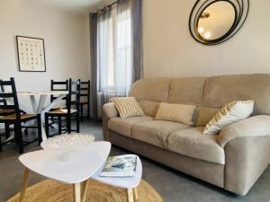 una sala de estar con un sofá y una mesa en Le SENS UNIQUE, en Rodez