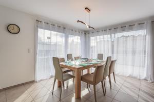 a dining room with a table and chairs at Villa Kaino 1 - Climatisée avec jardin in Ondres +5 photos