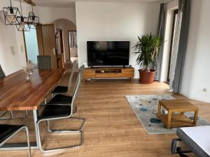 a living room with a table and a flat screen tv at Superschöne 4-Zimmerwohnung in Hallstadt