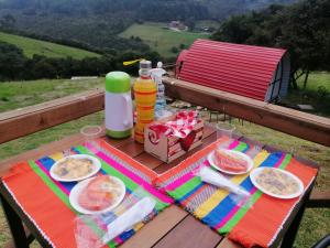 GachancipáにあるGlamping La Guadalupanaのピクニックテーブル(食べ物と飲み物の盛り合わせ付)