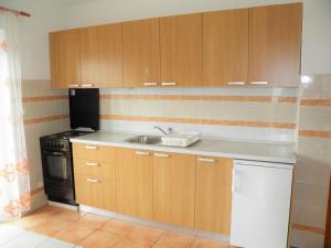 a kitchen with wooden cabinets and a sink at Apartments Miljenka in Baška