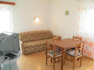 a living room with a table and a couch at Apartments Miljenka in Baška