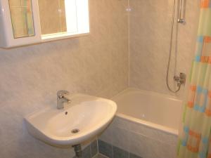 a bathroom with a sink and a bath tub at Apartments Miljenka in Baška +31 photos