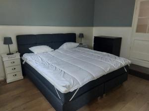 a bedroom with a large bed with white sheets at Cosy appartment in Arnhem