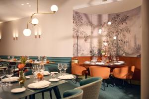a dining room with tables and chairs and chandeliers at Van der Valk Hotel Park Lane Antwerpen in Antwerp +49 photos