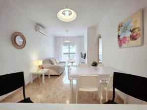 a white living room with a white table and chairs at Caballero de Rodas DaNuria in Torrevieja