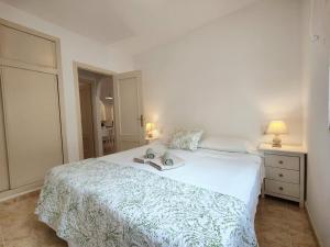 a bedroom with a white bed with a book on it at Caballero de Rodas DaNuria in Torrevieja +5 photos