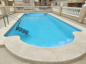 a large swimming pool with blue water in a building at Caballero de Rodas DaNuria in Torrevieja