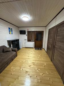 a living room with a couch and a wooden floor at Приватна садиба ~Smoky mountain~ in Polyana