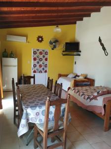 una camera da letto con due letti, un tavolo e delle sedie di Mic-Bau a Villa Elisa