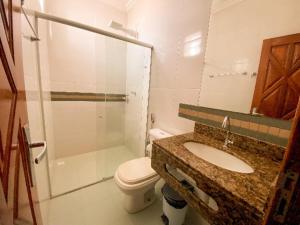 a bathroom with a sink and a toilet and a shower at Hotel Cantinho Verde in Teixeira de Freitas +36 photos