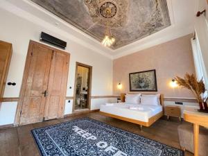 una camera con letto, tavolo e soffitto di Kurabiye Palas ad Alaçatı Altre 6 foto