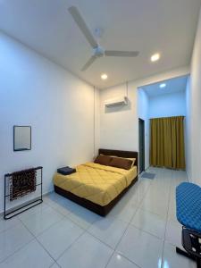 a bedroom with a bed and a ceiling fan at Haneya Homestay in Kampong Banggol Pasir