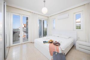 Un dormitorio blanco con una cama y ventanas. en Golden Heights 15, en Ölüdeniz 30 fotos más