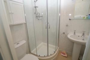 a bathroom with a shower and a toilet and a sink at Westward B&B in Newquay
