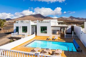 willa z basenem i górami w tle w obiekcie Villa Sol Y Mar w mieście Yaiza