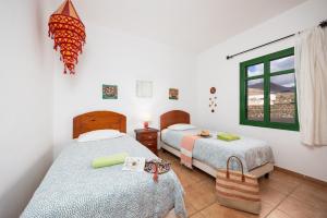 sypialnia z dwoma łóżkami i oknem w obiekcie Villa Sol Y Mar w mieście Yaiza +37 zdjęć