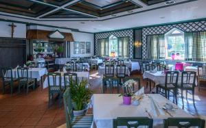 jadalnia z białymi stołami i krzesłami w obiekcie Hotel Walserwirt w mieście Wals-Siezenheim