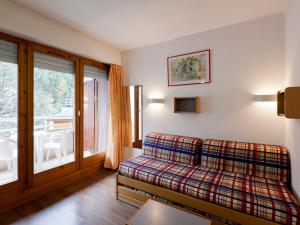 ein Wohnzimmer mit einer Couch und einem Fenster in der Unterkunft Studio Confortable pour 2 Personnes avec Balcon, Proche Télécabine et Spa à Brides-les-Bains - FR-1-512-114 in Brides-les-Bains