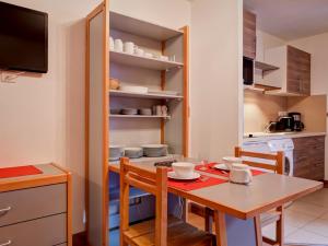 a small kitchen with a table and chairs and a kitchen with a kitchen at Studio rénové 4 pers avec balcon et lave-linge - FR-1-512-147 in Brides-les-Bains