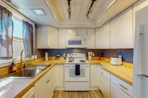 a kitchen with white cabinets and a stove top oven at Cozy Mountain Retreat in Flagstaff