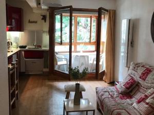 a living room with a couch and a table and a kitchen at Studio 4 Pers avec Balcon, Wi-Fi, Parking - Centre-ville Brides-les-Bains - FR-1-512-231 in Brides-les-Bains