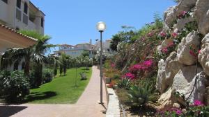 a street light next to a sidewalk with flowers at La Cala de Mijas, groundfloor 2 bed apartment steps away from the beach in Mijas Costa