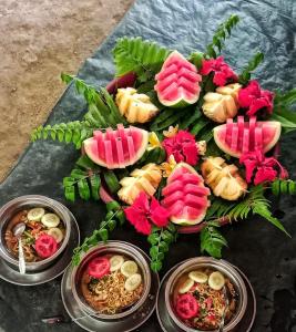 a table topped with plates of food and flowers at Umiyuki jungle tour only treking with us in Bukit Lawang