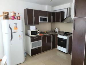 a kitchen with a white refrigerator and a microwave at Carilo in Villa Carlos Paz