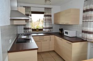 a kitchen with white cabinets and a sink and a microwave at Ferienwohnung Gabler in Landsberg am Lech