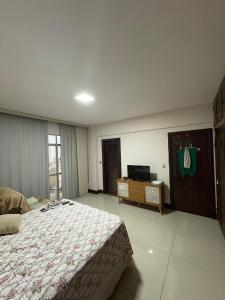 a bedroom with a bed and a dresser and a television at COP 30 - Apartamento Amplo in Belém