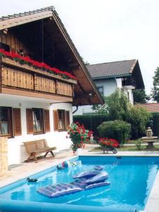 una piscina frente a una casa en Ferienwohnung Löster, en Bernau am Chiemsee