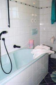 y baño con bañera azul y toallas. en Ferienwohnung Löster, en Bernau am Chiemsee