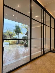 eine große Glastür mit Gartenblick in der Unterkunft Olympian Altis Hotel in Olympia