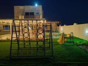 un parco giochi in un cortile di notte di استراحة آدم a Barka