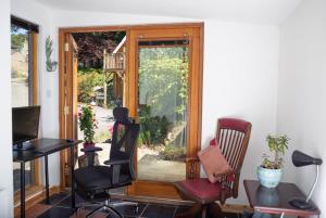 a room with chairs and a sliding glass door at Den of Allachlade in Aboyne