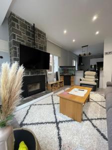 ein Wohnzimmer mit Kamin und Fernseher in der Unterkunft La Casina de San Lorenzo in Gijón