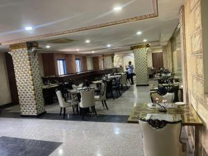 un ristorante con tavoli, sedie e un pianoforte di SG - AA Hotel ad Abuja