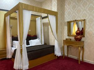 una camera con letto a baldacchino e specchio di SG - AA Hotel ad Abuja