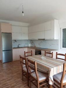 a kitchen with a table and chairs and a refrigerator at Apartments Salai in Lukovë
